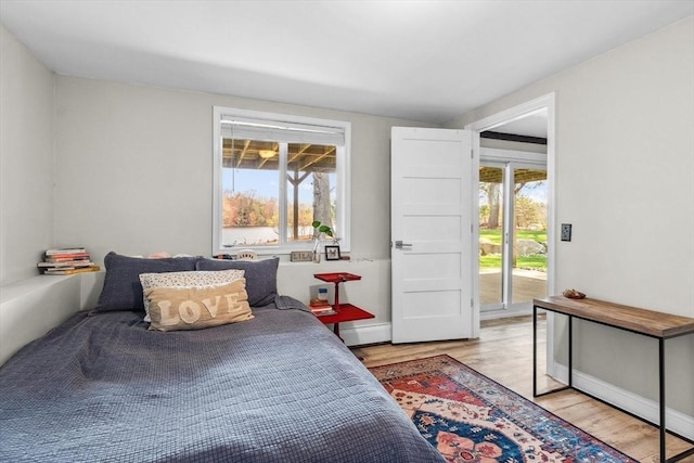 bedroom featuring light wood-style floors and access to outside
