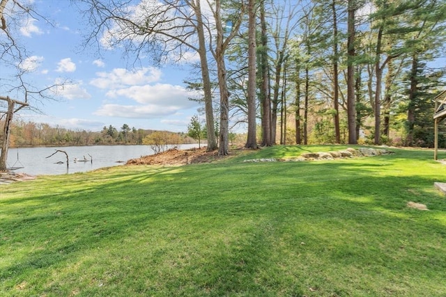 view of green lawn with a water view