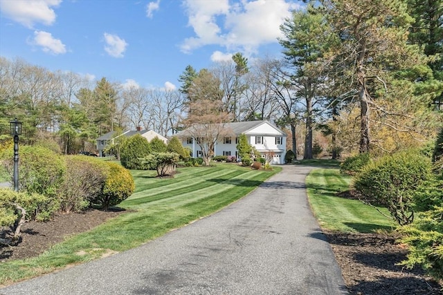 view of front facade with asphalt driveway, a front yard, and a garage