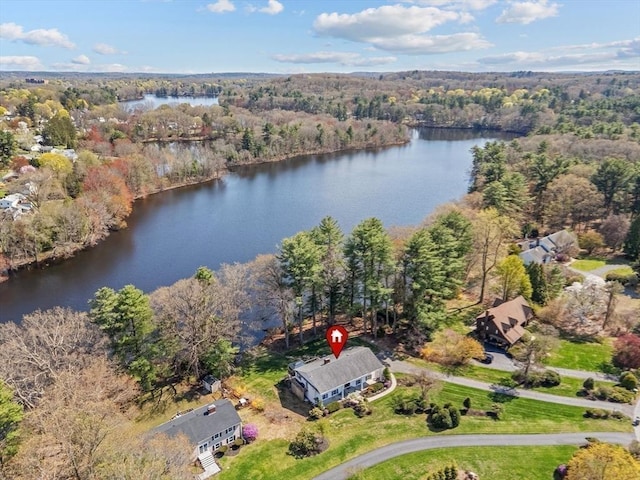 aerial view of property's location with a heavily wooded area and a nearby body of water