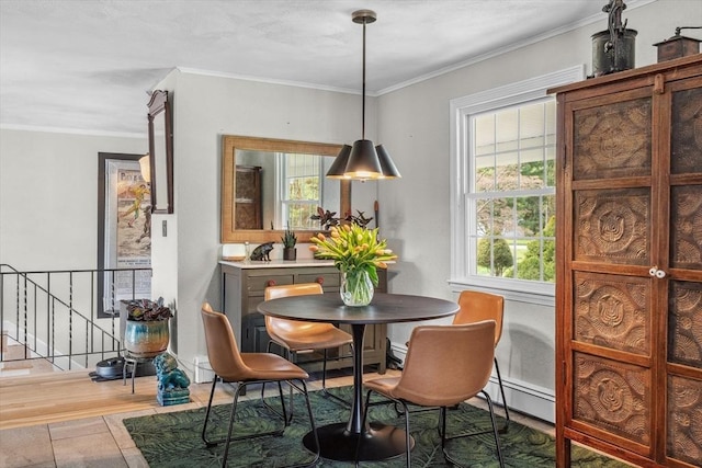 dining space featuring healthy amount of natural light, wood finished floors, crown molding, and baseboard heating