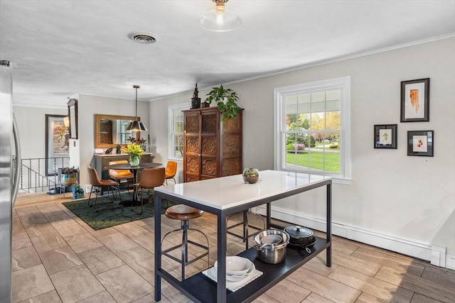 dining area with a baseboard radiator, crown molding, and baseboards