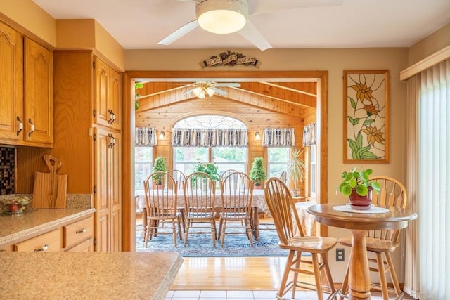 dining area with a ceiling fan, plenty of natural light, and wooden walls