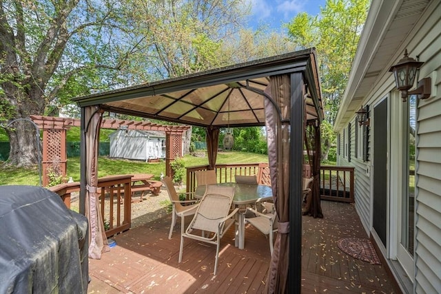 wooden deck with outdoor dining area, a gazebo, and a lawn