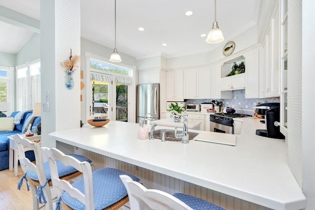 8 Barn Ln, Gloucester, MA 01930 - kitchen with appliances with stainless steel finishes, a peninsula, pendant lighting, tasteful backsplash, and recessed lighting