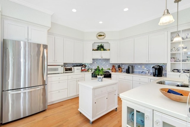 8 Barn Ln, Gloucester, MA 01930 - kitchen with freestanding refrigerator, white microwave, stove, white cabinets, and ornamental molding