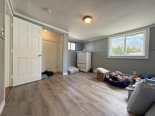 bedroom featuring ornamental molding, wood finished floors, and baseboards