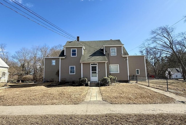 view of front of home featuring entry steps, a chimney, and fence