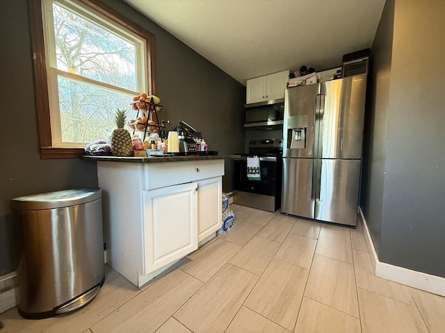 kitchen with baseboards, appliances with stainless steel finishes, wood finish floors, and white cabinets