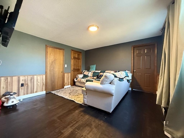 living area featuring a wainscoted wall, a textured ceiling, and wood finished floors