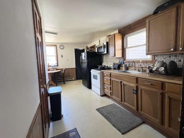 kitchen with light floors, white electric range, stainless steel microwave, wainscoting, and a sink