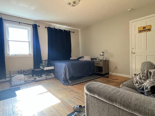 bedroom featuring baseboards and wood finished floors