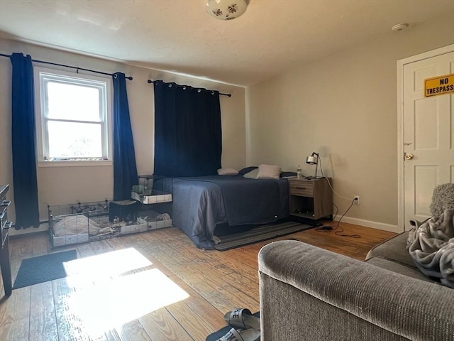 bedroom featuring wood finished floors and baseboards