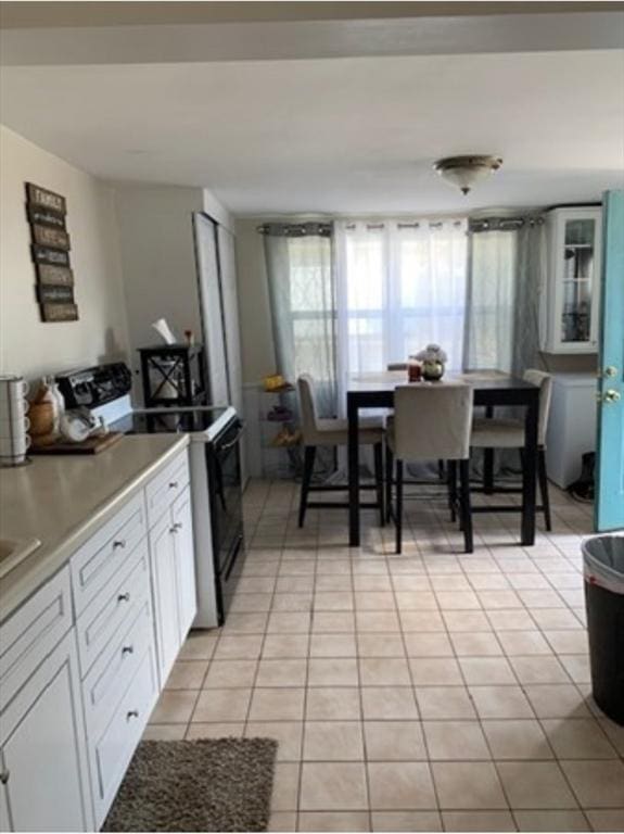 kitchen featuring white cabinetry, range with electric stovetop, and light tile patterned floors