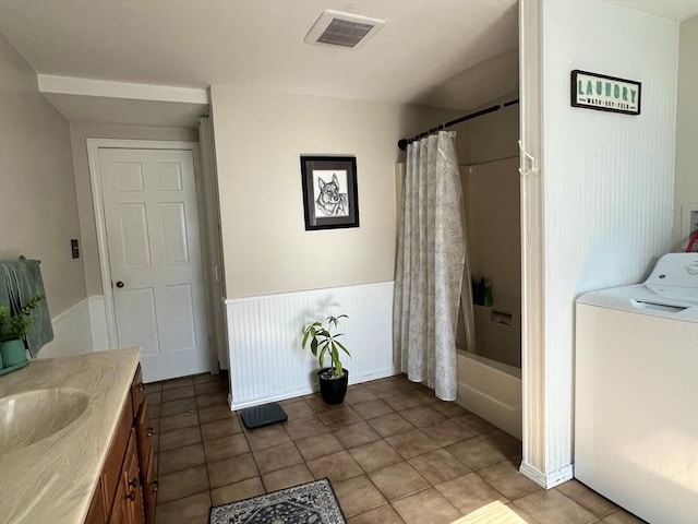 bathroom featuring a wainscoted wall, washer / clothes dryer, visible vents, shower / bathtub combination with curtain, and vanity