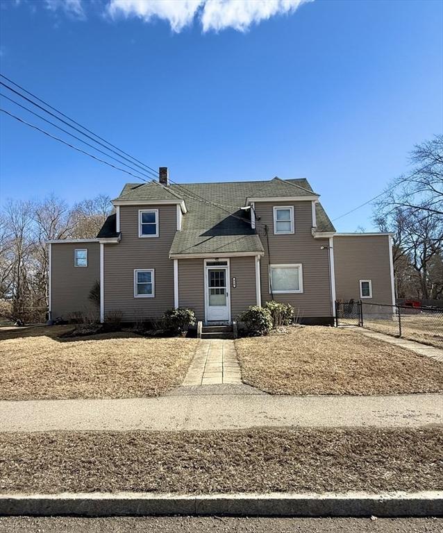 traditional-style house featuring entry steps, fence, and a chimney