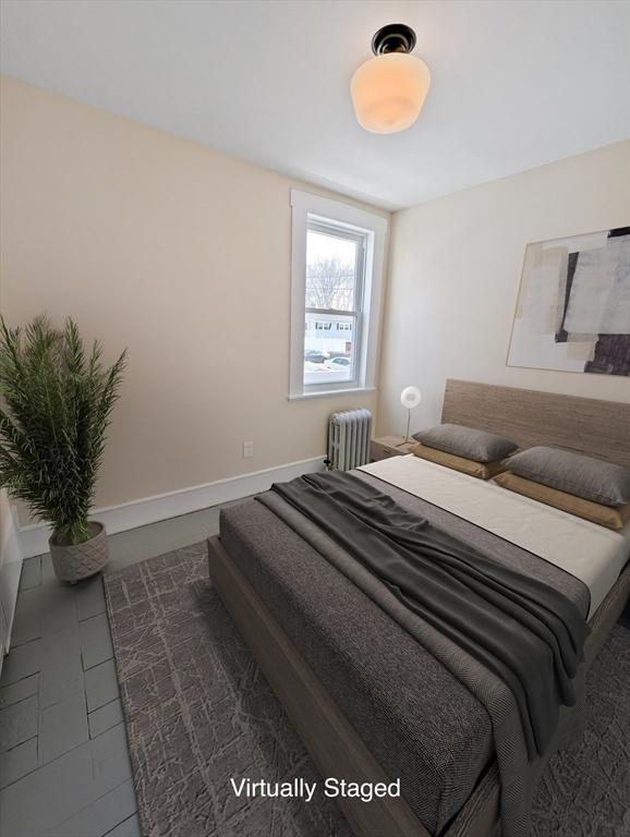 bedroom with radiator and baseboards