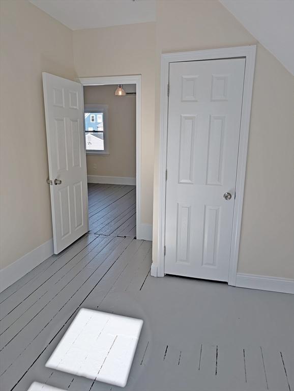 hall with hardwood / wood-style flooring and baseboards