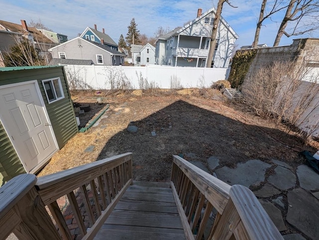 view of yard with a residential view, an outbuilding, and fence