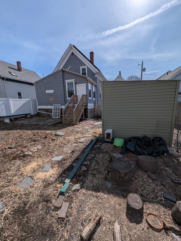 rear view of house featuring fence