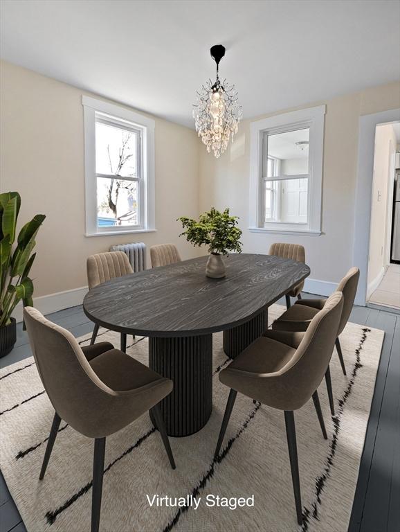 dining space featuring baseboards, an inviting chandelier, and wood finished floors