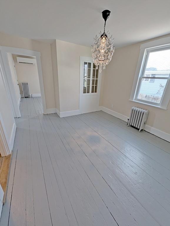 unfurnished dining area with radiator heating unit, baseboards, and light wood finished floors