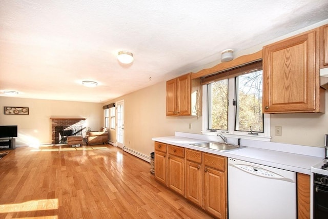 kitchen featuring a baseboard radiator, open floor plan, white dishwasher, light countertops, and a sink