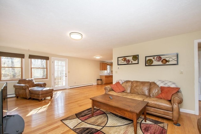 living area with light wood-style flooring, baseboards, and baseboard heating