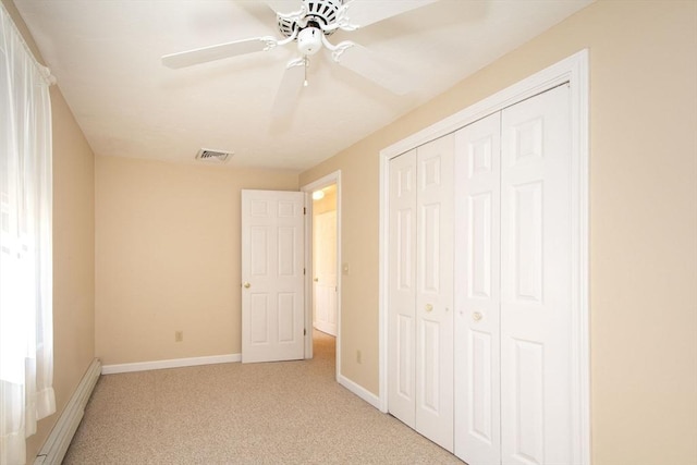 unfurnished bedroom with light carpet, a closet, a baseboard radiator, and visible vents