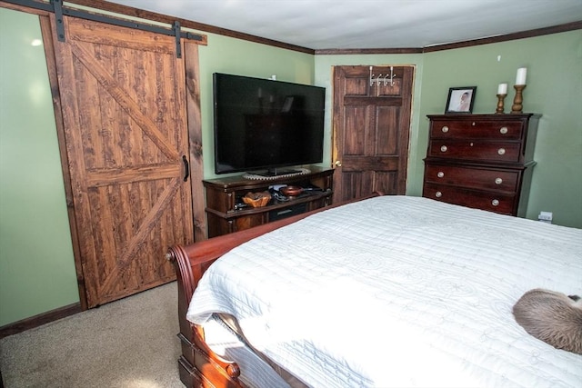 bedroom with a barn door, carpet floors, baseboards, and crown molding