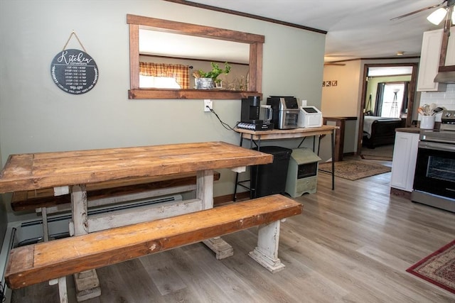 dining area with a ceiling fan, light wood finished floors, and ornamental molding