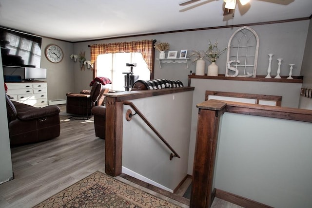 interior space featuring ornamental molding, a baseboard radiator, and wood finished floors