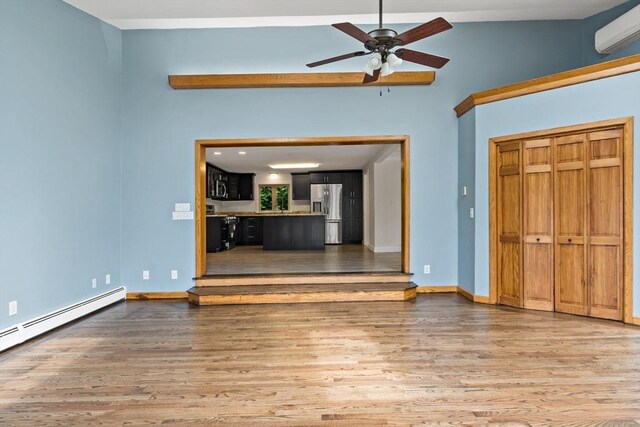 43 Water St, Freetown, MA 02702 - unfurnished living room featuring a wall unit AC, wood finished floors, a ceiling fan, and a baseboard heating unit