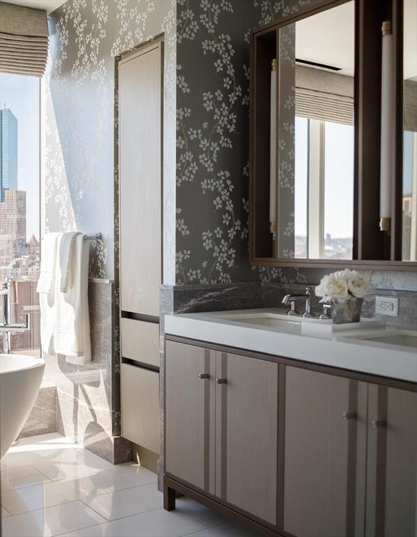 bathroom with vanity, a bathing tub, and tile patterned flooring