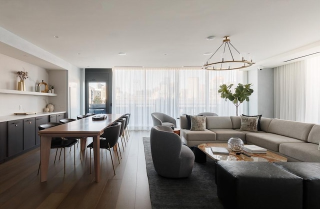 living room with floor to ceiling windows, a notable chandelier, and dark hardwood / wood-style flooring