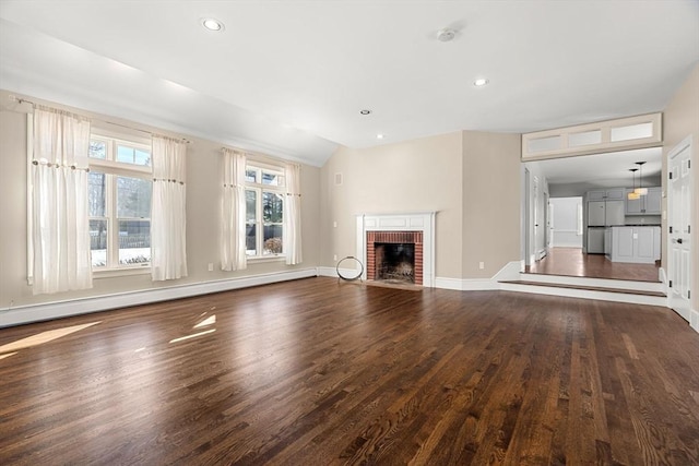 unfurnished living room with a brick fireplace, a baseboard heating unit, baseboards, recessed lighting, and wood finished floors