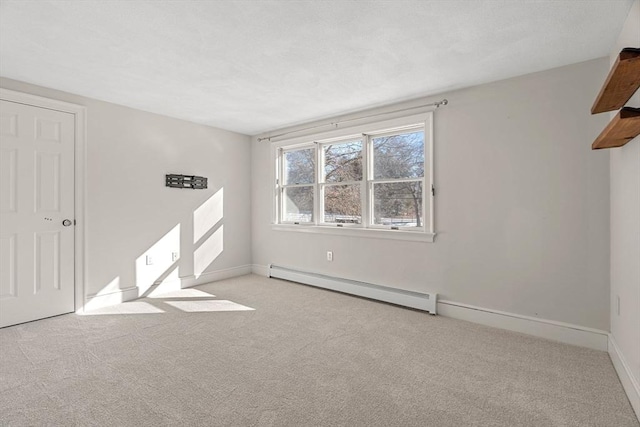 spare room featuring baseboards, carpet, and a baseboard radiator