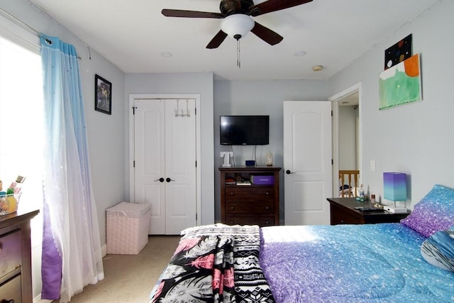 bedroom with a closet, ceiling fan, and carpet flooring