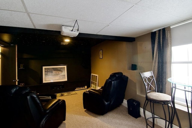 carpeted home theater with a paneled ceiling