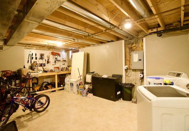 basement featuring separate washer and dryer, electric panel, and a workshop area