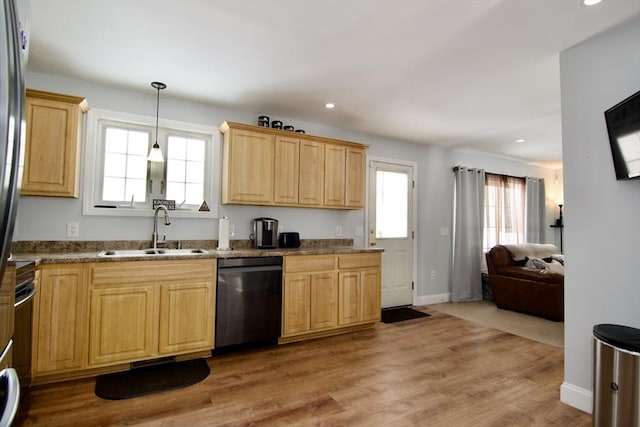 kitchen with sink, light wood-type flooring, black dishwasher, pendant lighting, and light stone countertops