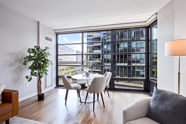 580 Washington St Unit 10F, Boston, MA 02111 - dining area featuring expansive windows, healthy amount of natural light, and wood finished floors