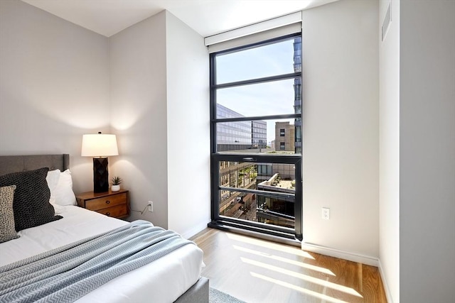 580 Washington St Unit 10F, Boston, MA 02111 - bedroom with wood finished floors and floor to ceiling windows