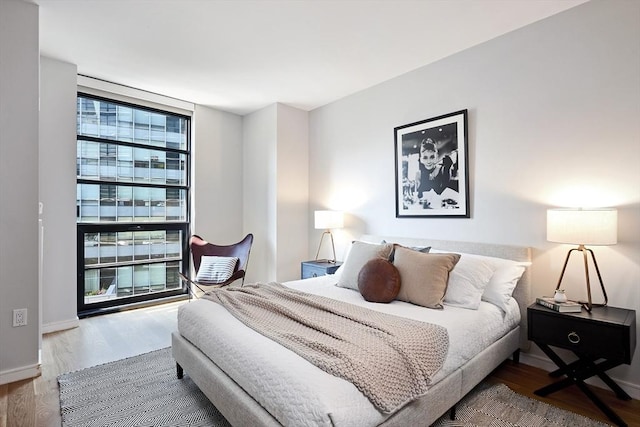 580 Washington St Unit 10F, Boston, MA 02111 - bedroom with wood finished floors and a wall of windows