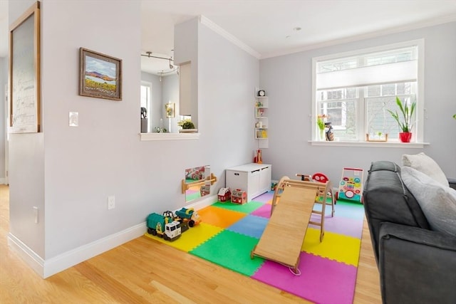 game room with hardwood / wood-style flooring and ornamental molding