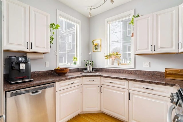 kitchen with white cabinetry, appliances with stainless steel finishes, light hardwood / wood-style floors, and sink