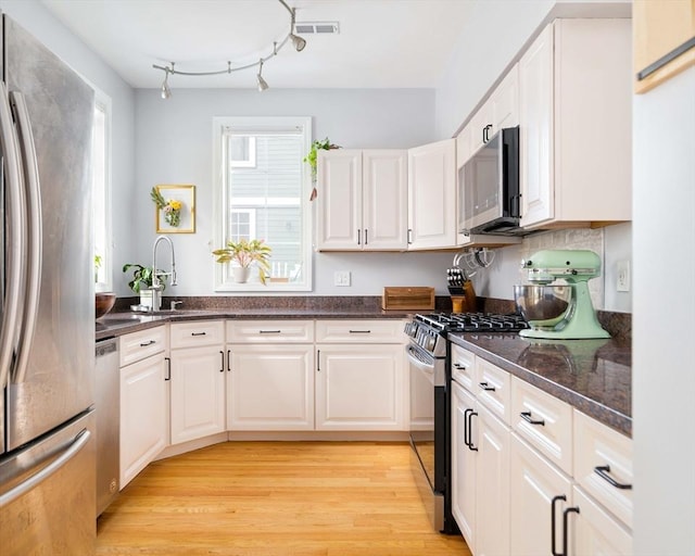 kitchen with white cabinetry, stainless steel appliances, and sink