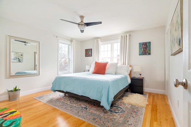 bedroom featuring multiple windows, hardwood / wood-style floors, and ceiling fan