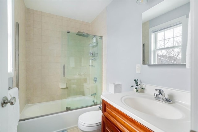 full bathroom featuring vanity, combined bath / shower with glass door, and toilet