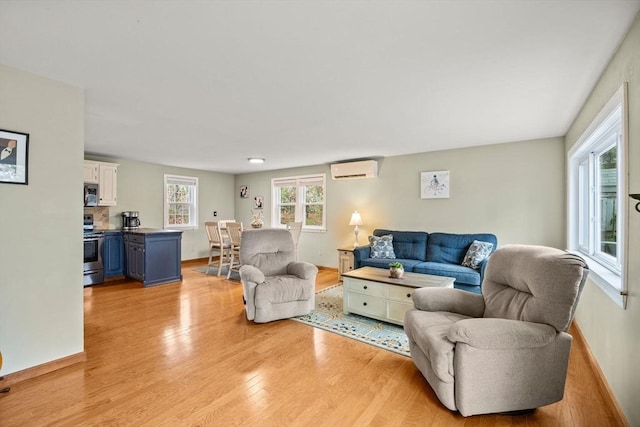 living room with light hardwood / wood-style flooring and an AC wall unit